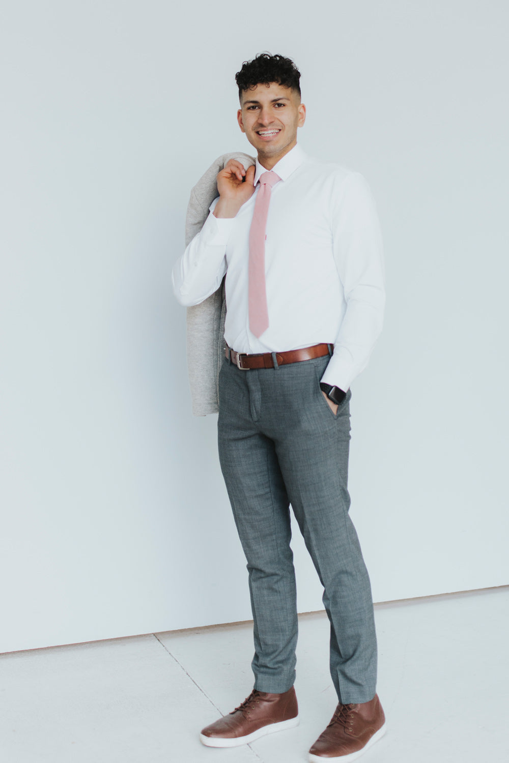 Blush Tie worn with a white shirt, brown belt and gray pants.