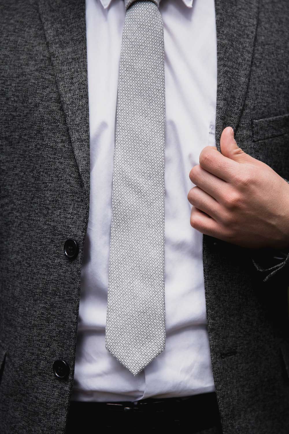 Calm tie worn with white shirt and textured charcoal gray suit jacket.