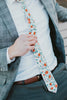 Citrus tie worn with a white shirt, gray plaid blazer and gray pants.