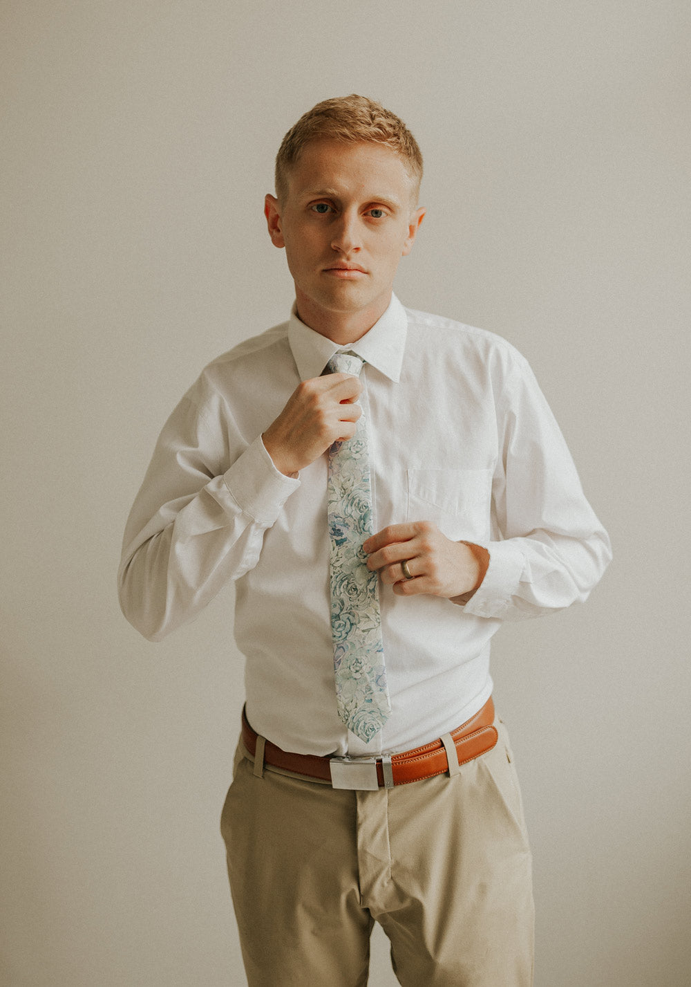 Crested Sunburst tie worn with a white shirt, brown belt and khaki pants.
