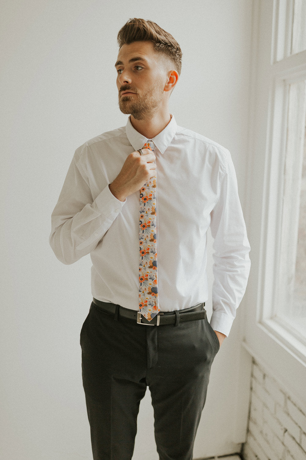 Desert Poppy tie worn with a white shirt, black belt and black pants.