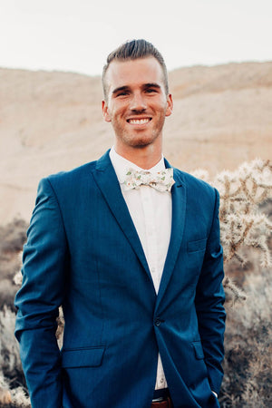 Desert Sun Bow Tie worn with a white shirt and navy suit jacket.