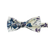 Dreamy Fields Pre-Tied Bow Tie. Cream background with dusty blue, white and gray flowers with navy blue and purple leaves.