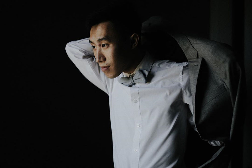 Dusty Bow Tie worn with a white shirt and dark gray suit jacket.