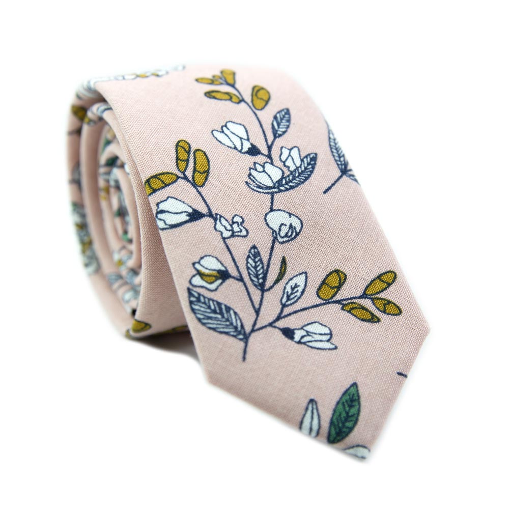 Dusty Lily Skinny Tie. Light pink background with white and green leaves and flowers, black stems, and some orange accents.
