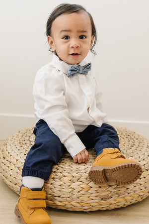 East Coast pre-tied bow tie worn with a white shirt and blue pants, light brown boots.