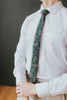 Evergreen tie worn with a white shirt, brown belt and tan and white plaid pants.