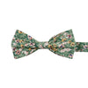 Faded Jade Pre-Tied Bow Tie. Sage background with white, blush and yellow flowers with blue flower centers, dark sage leaves.