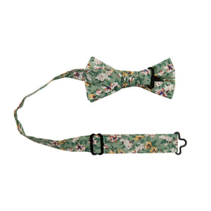 Faded Jade Pre-Tied Bow Tie with adjustable neck strap. Sage background with white, blush and yellow flowers with blue flower centers, dark sage leaves.