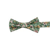 Faded Jade Pre-Tied Bow Tie. Sage background with white, blush and yellow flowers with blue flower centers, dark sage leaves.