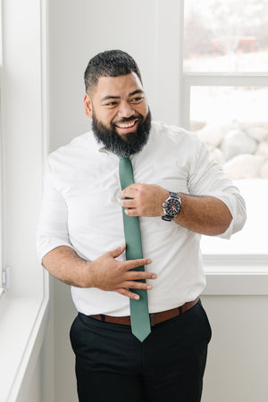 Forest tie worn with a white shirt and black pants. 