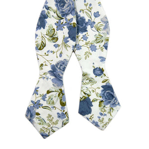 Frisco Self Tie Bow Tie. White background with small and medium size light blue flowers and sage green leaves.