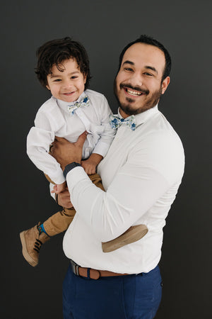 Frisco pre-tied bow ties worn by father and son wearing white long sleeve shirts. 