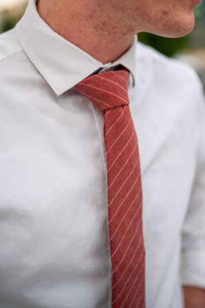 Garnet tie worn with a white shirt.