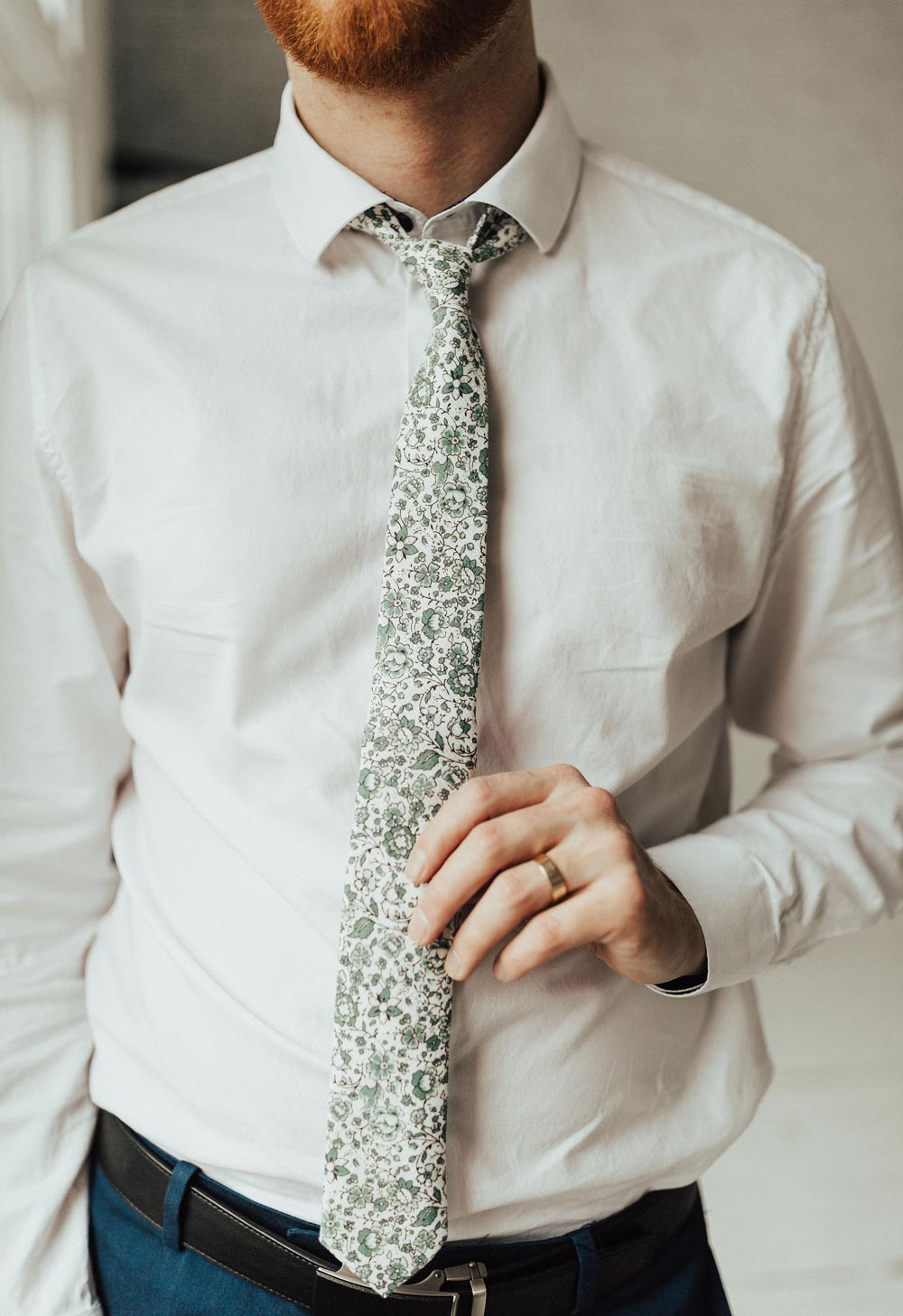 Hidden Garden tie worn with a white shirt, black belt and blue pants.
