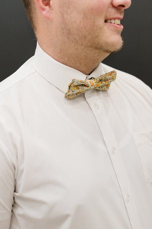 Honey pre-tied bow tie worn with a white shirt.