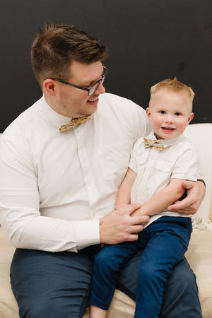 Honey pre-tied bow tie worn by a father and son with a white shirt and blue pants.