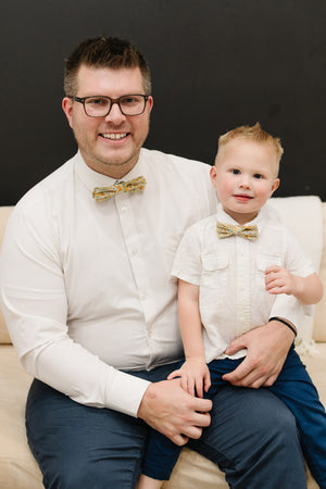 Honey pre-tied bow tie worn by a father and son with a white shirt and blue pants.