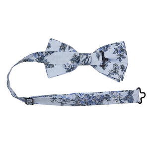 Indie Skye Pre-Tied Bow Tie with adjustable neck strap. Dusty blue background with white, blue, black and gray floral leaf pattern.