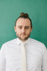 Ivory tie worn with a white shirt.