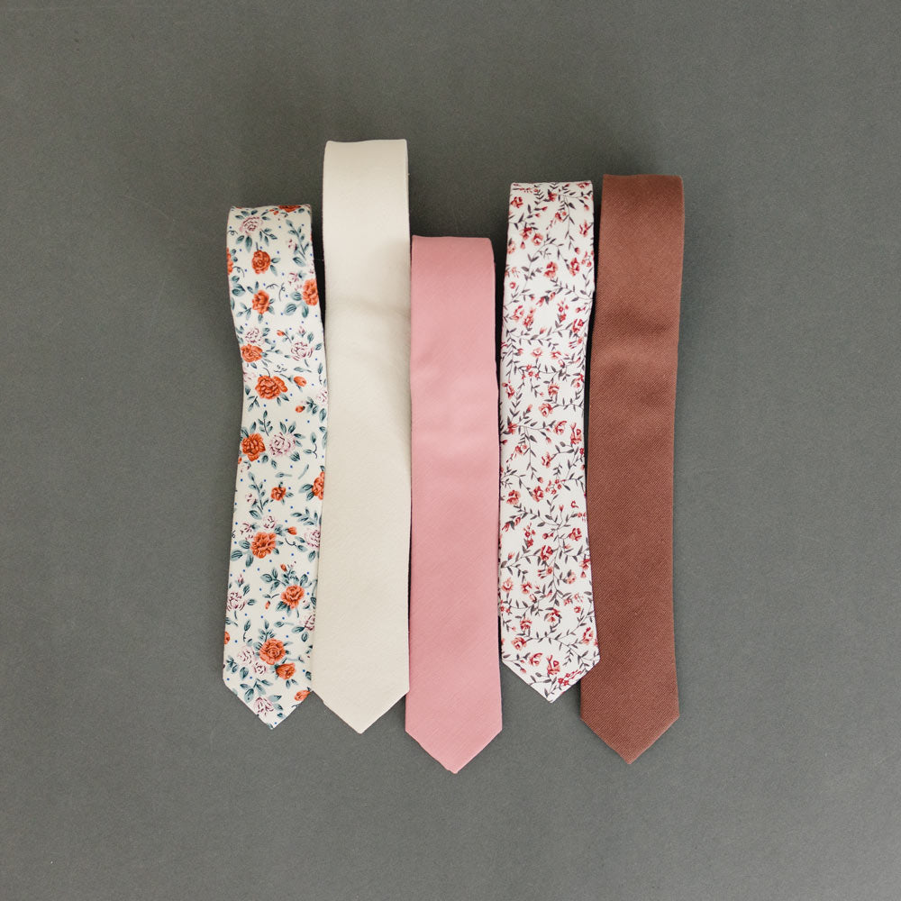 Five skinny ties laying next to one another.