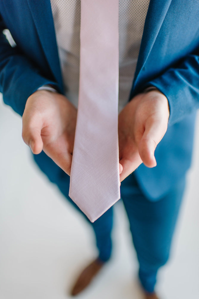 Lavender tie worn with a white shirt and royal blue suit and brown shoes.
