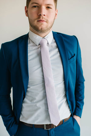 Lavender tie worn with a white shirt and royal blue suit.