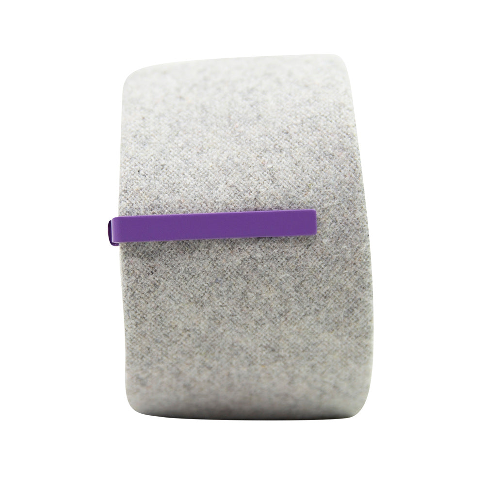 Solid lavender metal tie bar clipped onto a gray textured wool tie that is rolled up.