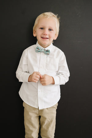 Leid Back pre-tied bow tie worn with a white shirt and tan pants.