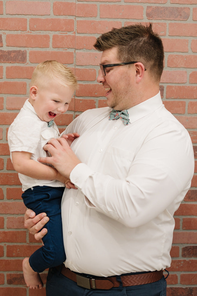Leid Back pre-tied bow tie worn by a father and son with a white shirt and navy blue pants.