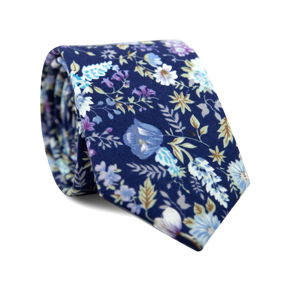 Lilac Skinny Tie. Navy background with blue, purple and white flowers, and green leaves and branches.