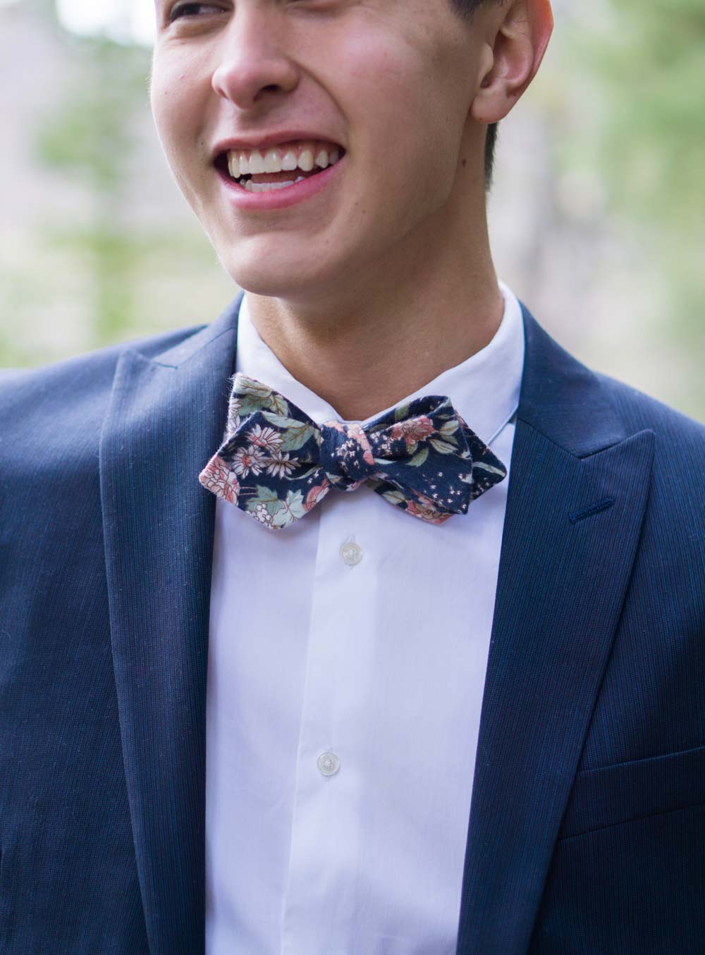 Lotus Bow Tie worn with a white shirt and navy suit jacket.