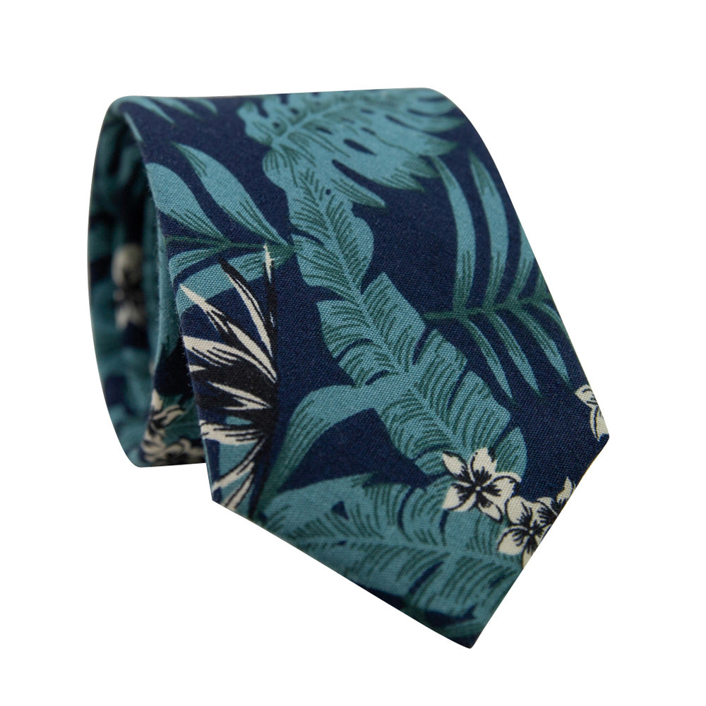 Lush Skinny Tie. Navy blue background with big green leaves and small cream and black flowers throughout. 