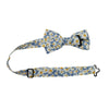 Mahalo Floral Pre-Tied Bow Tie with adjustable neck strap. Dusty blue background with medium sized white and yellow daisy flowers throughout.