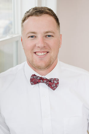 Mahogany pre-tied bow tie worn with a white shirt.
