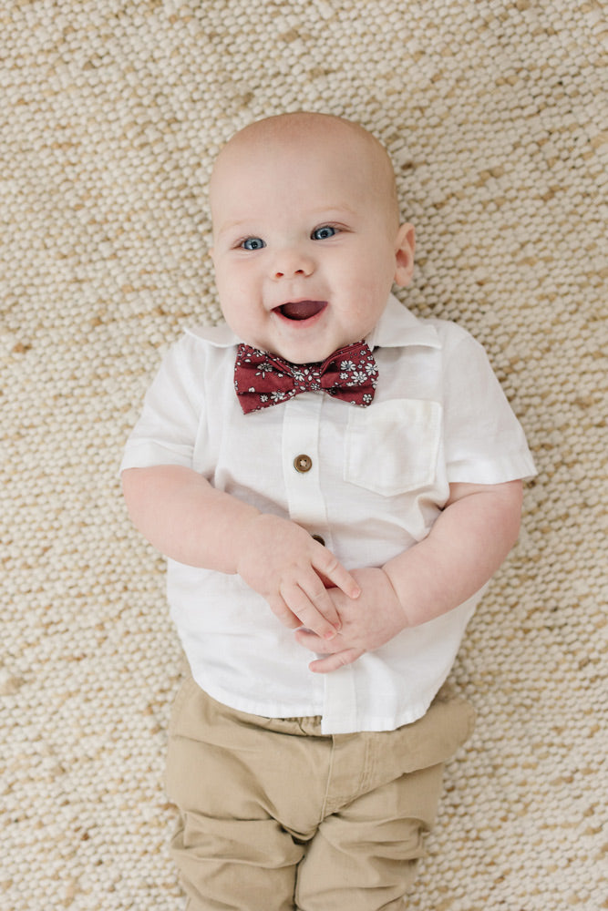 Mahogany pre-tied bow tie worn with a white shirt and tan pants.
