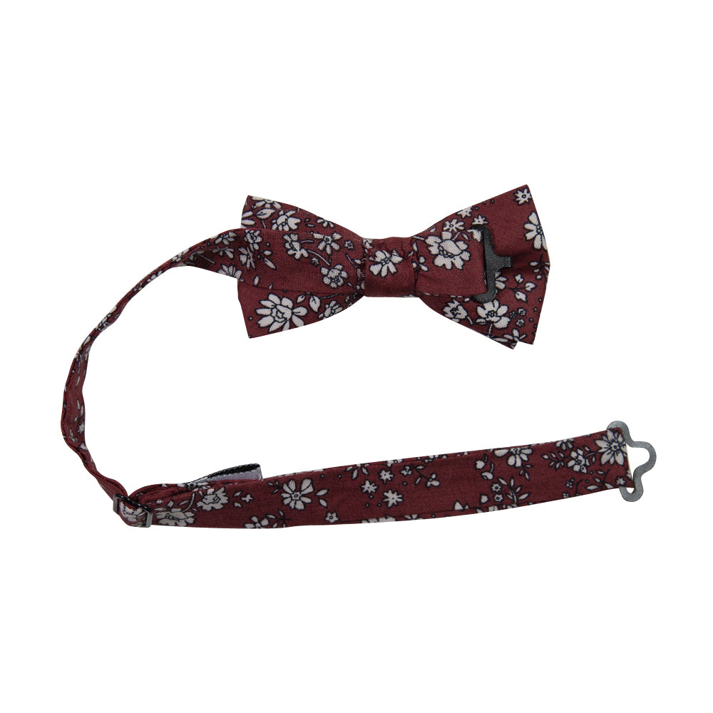 Mahogany Floral Pre-Tied Bow Tie with adjustable neck strap. Burgundy background with small white flowers and black stems throughout.