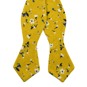 Marigold Self Tie Bow Tie. Yellow background with small white, black and blue flowers.
