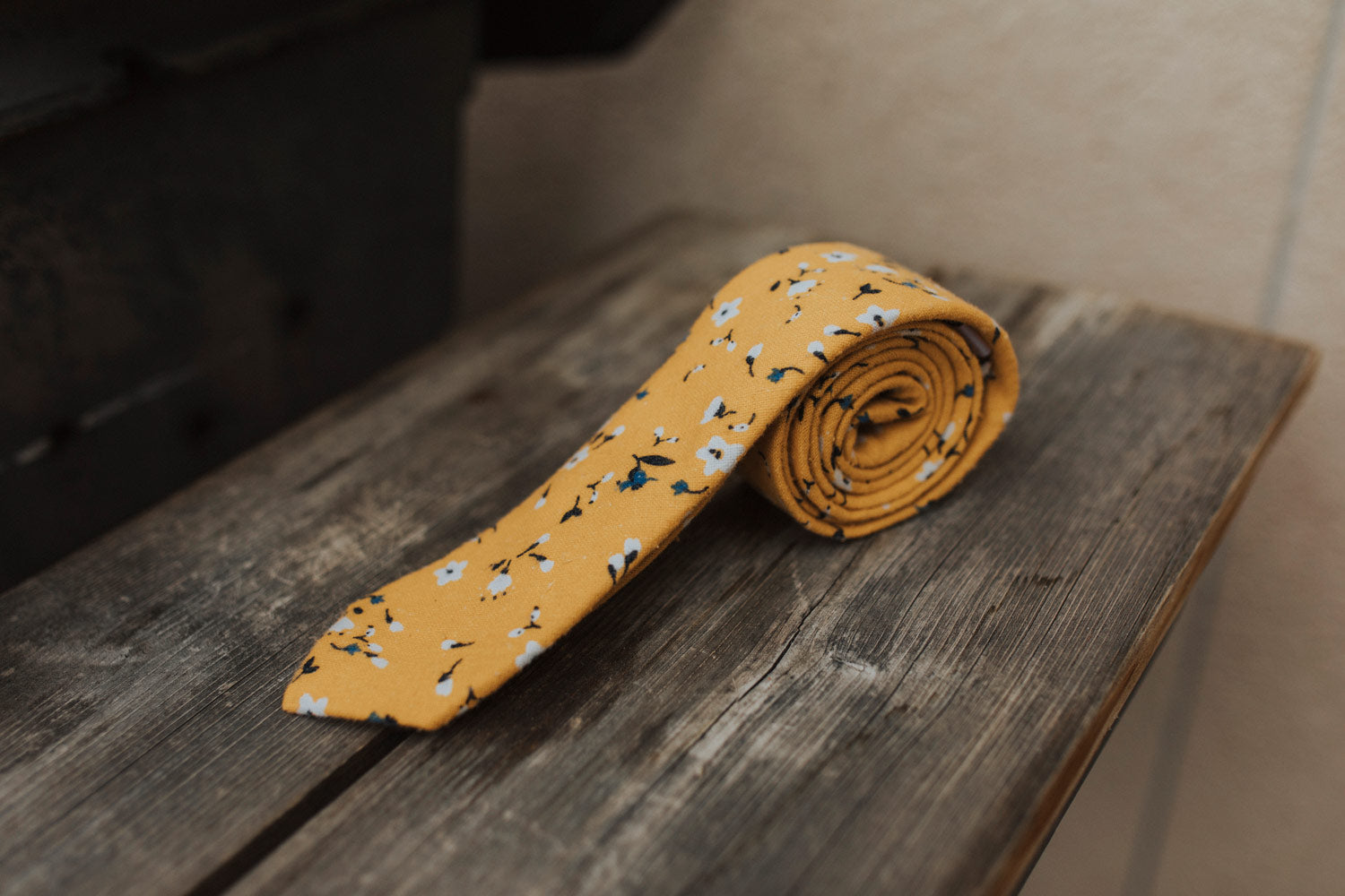 Marigold tie sitting on a wooden bench.