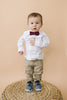 Merlot pre-tied bow tie worn by a young boy in a white shirt and tan pants. 