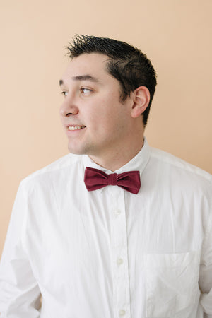 Merlot pre-tied bow tie worn with a white long sleeve shirt. 