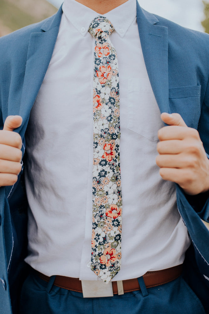Orange Pansy tie worn with a white shirt, brown belt and royal blue suit.