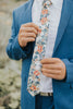 Orange Pansy tie worn with a white shirt, brown belt and royal blue suit.