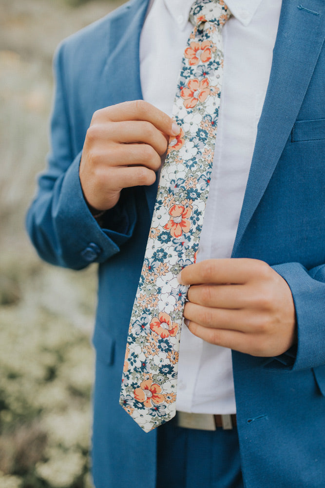 Orange Pansy tie worn with a white shirt, brown belt and royal blue suit.