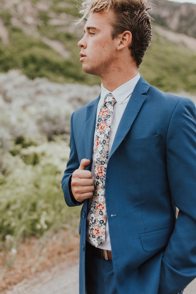 Orange Pansy tie worn with a white shirt, brown belt and royal blue suit.