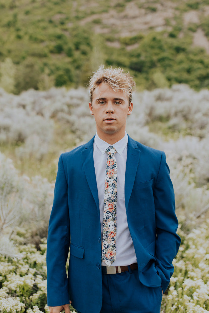 Orange Pansy tie worn with a white shirt, brown belt and royal blue suit.