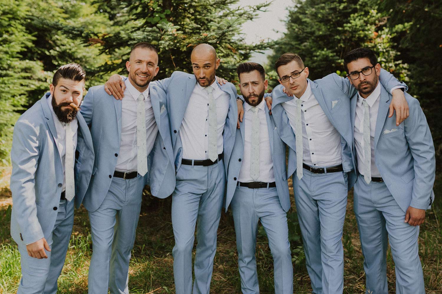 Palm tie worn by 6 groomsmen at a wedding wearing white shirts and light blue suits.