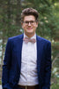 Peach Blossom Bow Tie worn with a white shirt and navy suit jacket.