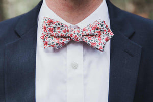 Peach Blossom Bow Tie worn with a white shirt and navy suit jacket.