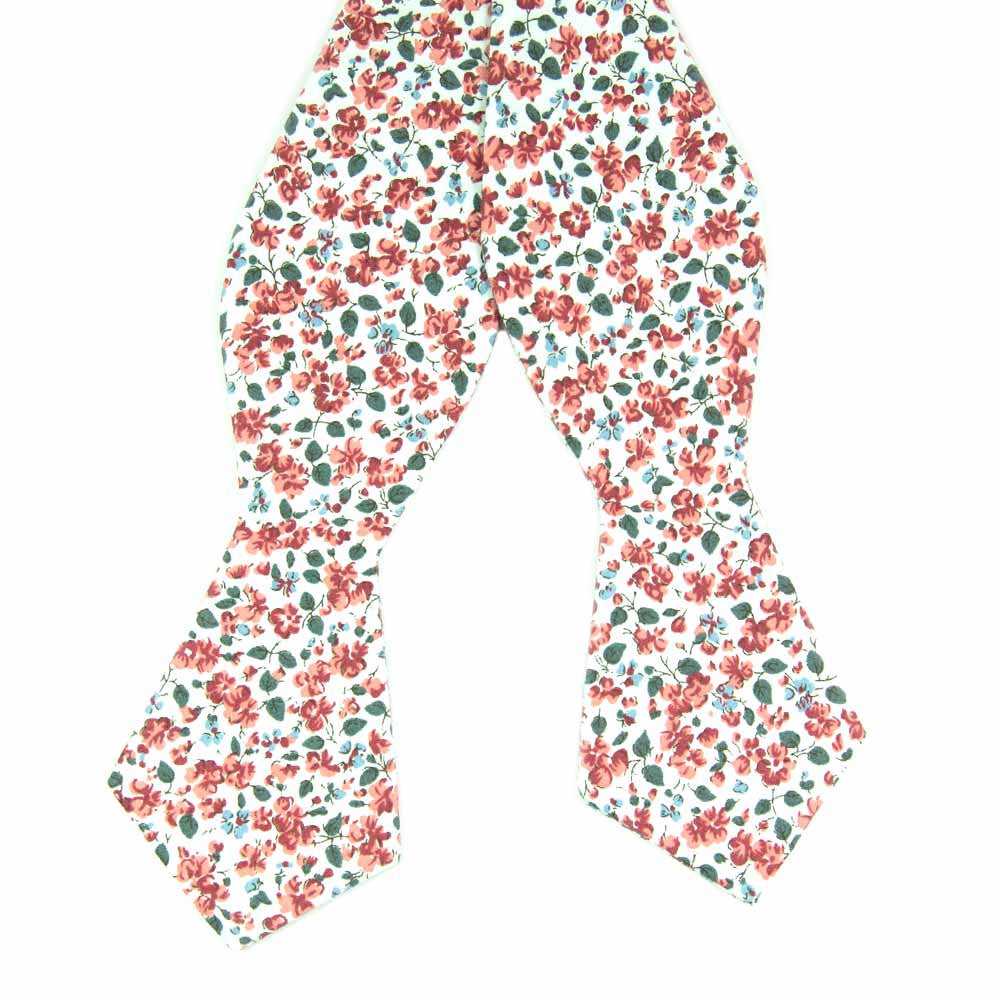 Peach Blossom Self Tie Bow Tie. White background with small red and dusty blue flowers and small green leaves.